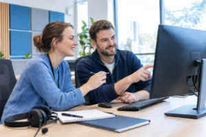 Dois administradores de alojamento discutem uma falha num domínio perante um monitor com imagem ilegível.